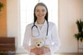 Portrait of pleasant smiling nurse holding toy.
