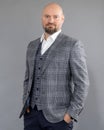 Portrait of pleased bearded middle-aged businessman in grey jacket, vest, white shirt, stand holding hands into pockets. Royalty Free Stock Photo