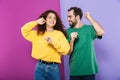 Portrait of pleased caucasian couple man and woman in colorful clothing having fun and dancing together