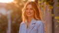 Portrait pleased happy Caucasian blonde girl with long hair stands sun rays background looking at camera smiling Royalty Free Stock Photo