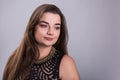 Portrait of a plus size female model posing in black dress over grey background. Royalty Free Stock Photo