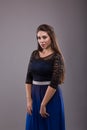 Portrait of a plus size female model posing in black dress over grey background. Royalty Free Stock Photo