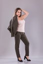 Portrait of a plus size female model posing in broun suit over grey background. Royalty Free Stock Photo