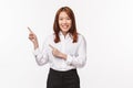 Portrait of polite nice asian lady in formal clothes, ointing fingers upper left corner and smiling camera, click here Royalty Free Stock Photo