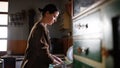 Poor mature woman washing dishes indoors at home, poverty concept. Royalty Free Stock Photo