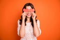 Portrait of positivce cheerful girl hold red little paper card heart hide her eyes play with boyfriend on 14-february Royalty Free Stock Photo