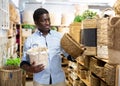 Positive african american man choosing storage wicker basket at store