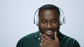 Portrait of positive african man listening music on earphones in studio. Royalty Free Stock Photo