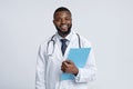 Portrait of positive black doctor holding medical chart