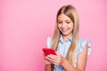 Portrait of positive blogger kid girl use smart phone enjoy social media news subscribe comment repost wear denim jeans