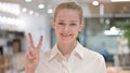 Portrait of Positive Businesswoman showing Victory Sign by Hand Royalty Free Stock Photo