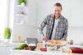 Portrait of positive cheerful gourmet guy enjoy proper nutrition weekend cook fresh salad add sliced tomato wear casual