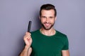 Portrait of positive cheerful guy demonstrate hairbrush enjoy anti dander haircare procedure wear good look outfit