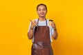 Portrait of positive cheerful man holding paper cup with finger showing sales discount over yellow background Royalty Free Stock Photo