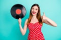 Portrait of positive cheerful red hair girl enjoy listen retro gramophone music hold turntable disc show thumb up sign Royalty Free Stock Photo