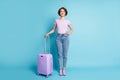 Portrait of positive cheerful traveler hold suitcase ready departure destination wear good look clothes gumshoes