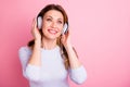 Portrait of positive cheerful woman have holidays sue headset listen music songs radio wear white jumper  over Royalty Free Stock Photo