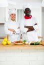 Portrait of positive chef and cook in kitchen