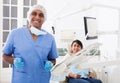 Portrait of positive dentist in dental office on background of patient