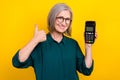 Portrait of positive elderly person demonstrate thumb up nfc paypass isolated on yellow color background