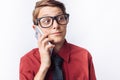 Portrait of positive and emotional schoolboy talking on phone, white background, glasses, red shirt, business theme, advertising, Royalty Free Stock Photo