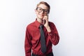 Portrait of positive and emotional schoolboy talking on phone, white background, glasses, red shirt, business theme, advertising, Royalty Free Stock Photo