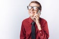 Portrait of positive and emotional schoolboy talking on phone, white background, glasses, red shirt, business theme, advertising, Royalty Free Stock Photo