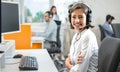 Portrait of positive female customer services agent with headset working in call center Royalty Free Stock Photo