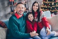 Portrait of positive friendly family sitting sofa hug hold hands enjoy fairy christmastime harmony indoors Royalty Free Stock Photo