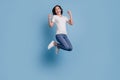 Portrait of positive funny crazy lady jump celebrate victory on blue background