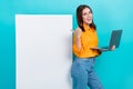 Portrait of positive funny cute girl with bob hair dressed yellow shirt indicating at banner hold laptop isolated on