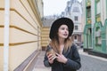 Portrait of a positive girl with a cup of drinks in her hands against a background of beautiful colored architecture. Royalty Free Stock Photo