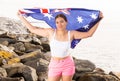 Portrait of a positive girl with the flag of Australia on the seashore on sunny day