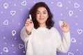 Portrait of positive good looking black haired woman holding tampon and hygiene pad, looking directly at camera, using tampon Royalty Free Stock Photo