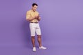 Portrait of positive handsome guy texting chatting cellphone on violet background Royalty Free Stock Photo