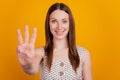 Portrait of positive lovely lady count fingers show three on yellow background