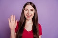 Portrait of positive nice friendly lady waving hand beaming smiling on violet background