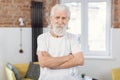 Portrait of pensioner in sport clothes posing at living room