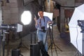 Portrait of positive photographer with his camera during photo shooting on town street Royalty Free Stock Photo