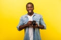 Portrait of positive photographer, joyous man in denim shirt holding professional digital dslr camera. isolated on yellow Royalty Free Stock Photo