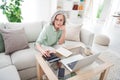 Portrait of positive pretty woman sit on sofa arm use calculator counting working from home indoors Royalty Free Stock Photo