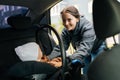 Portrait of positive pretty young mom placing child safety seat with infant baby boy on back passenger seat, smiling Royalty Free Stock Photo