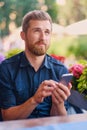 Positive redhead bearded male using a smartphone.