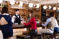 Portrait of barman and people who are standing near bar counter in luxurious restaurant Royalty Free Stock Photo