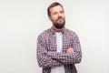 Portrait of positive thoughtful bearded man standing with crossed hands, looking aside with dreamy happy face. white background