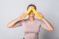 Portrait of positive woman covering eyes with corn cobs, fresh raw vegetables, concept of healthy eating Royalty Free Stock Photo