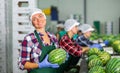 Portrait of positive woman fruit factory worker with watermelon