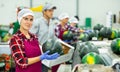 Portrait of positive woman fruit factory worker with watermelon