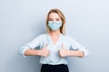 Portrait of positive woman showing two thumbs up wearing blue face mask isolated on grey background Royalty Free Stock Photo