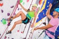 Couple of alpinist practicing in pair indoor rock-climbing Royalty Free Stock Photo
